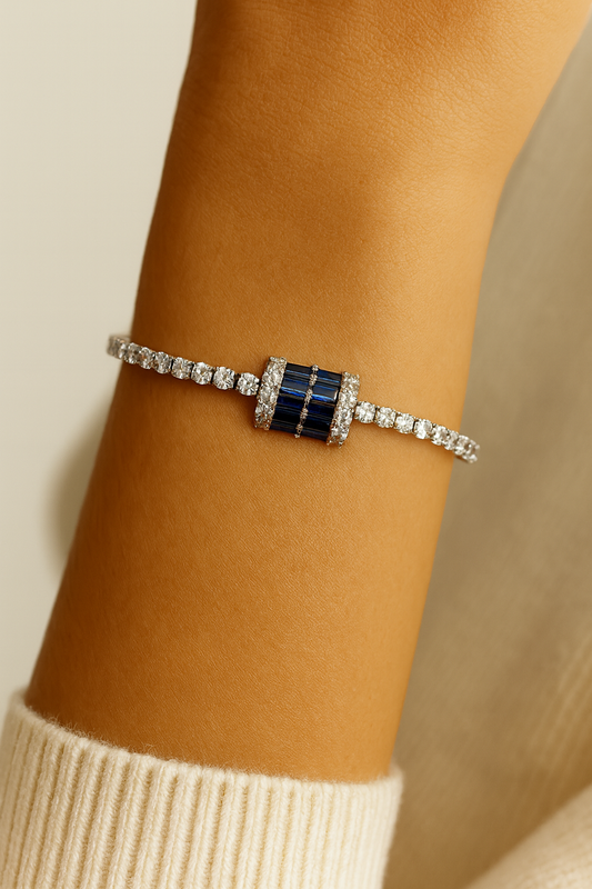 silver tennis bracelet with a bold blue crystal centerpiece