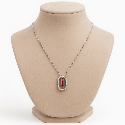 Elegant silver necklace featuring a deep red gemstone framed with sparkling stones