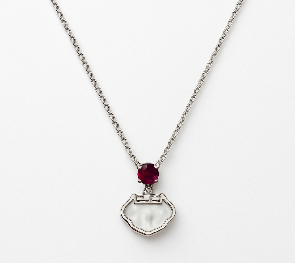 Delicate silver pendant featuring a Ruby gemstone and a sleek charm