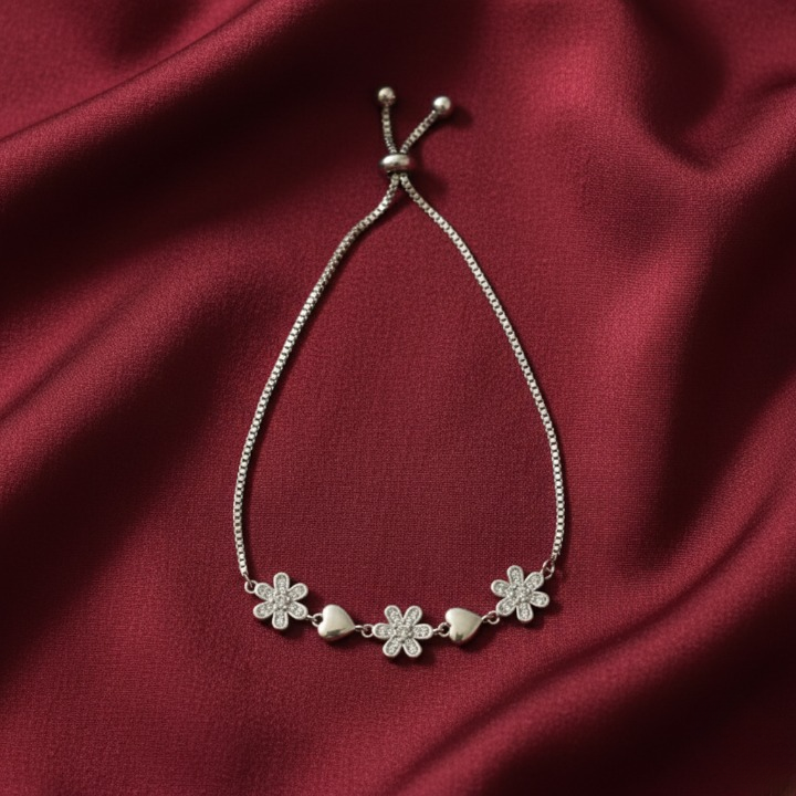 Silver bracelet featuring charming pave-set and crystal flowers with smooth silver hearts.