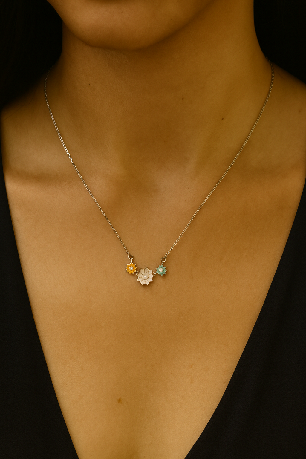 Delicate sterling silver necklace featuring three colorful floral charms