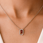 Elegant silver necklace featuring a deep red gemstone framed with sparkling stones