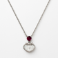 Delicate silver pendant featuring a Ruby gemstone and a sleek charm