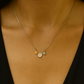 Delicate sterling silver necklace featuring three colorful floral charms